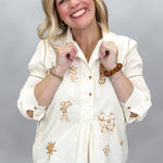 Ivy Jane ivory Milagro blouse with bronze embroidery and partial button front, collar held open.