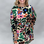 Back On 74 bold floral print midi dress, full-length front view on a model showing the cream-ground multicolor floral and leaf print, long sleeves, and knee-length hem.