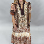 Blown My Cover cream bohemian floral midi dress, full front view showing the brown, beige, and rust paisley pattern, tiered skirt, and tan Mary Jane sandals.