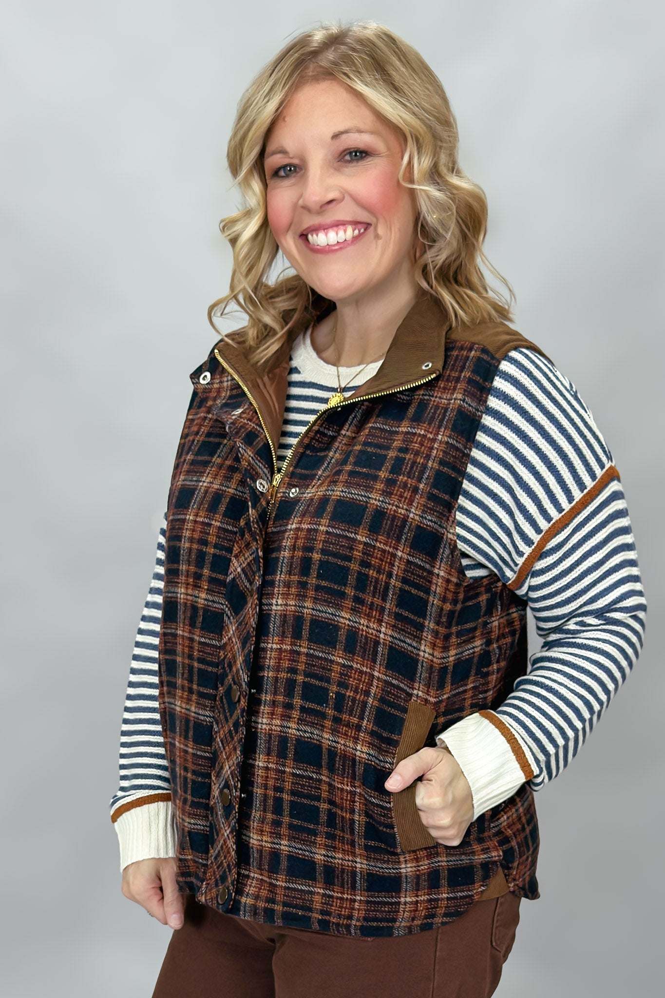 Staccato navy and brown plaid vest with mock neck and patch pockets; styling suggestion over a separate striped sweater.