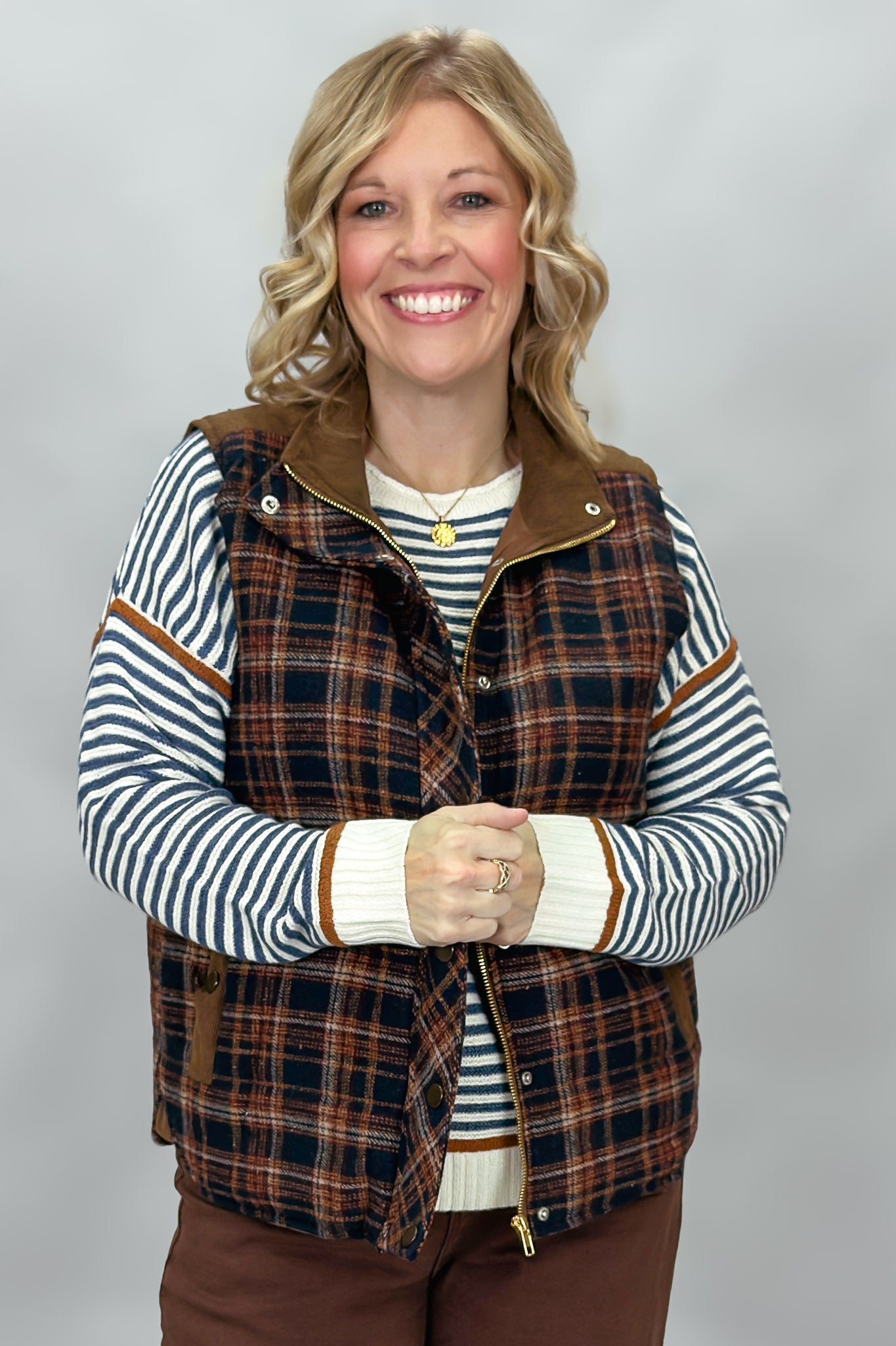 Staccato navy and brown plaid vest with mock neck and patch pockets; styling suggestion over a separate striped sweater.