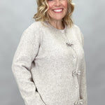 Compania Fantastica tan button-front cardigan with bow details; angled model view.