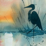 Silhouette of a heron against a colorful watercolor background with a lighthouse.