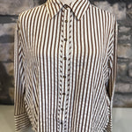 Striped shirt on a mannequin against a stone wall background