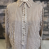 Striped shirt on a mannequin against a stone wall background