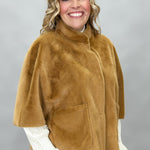 Ivy Jane camel faux fur cape with concealed snaps and patch pockets; angled model view.
