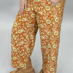Ivy Jane orange, cream and green floral wide-leg pants; angled model view.