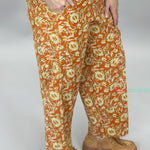 Ivy Jane orange, cream and green floral wide-leg pants; angled model view.
