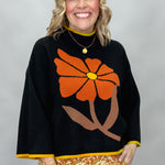 Ivy Jane black mock-neck sweater with a large orange flower; front model view.