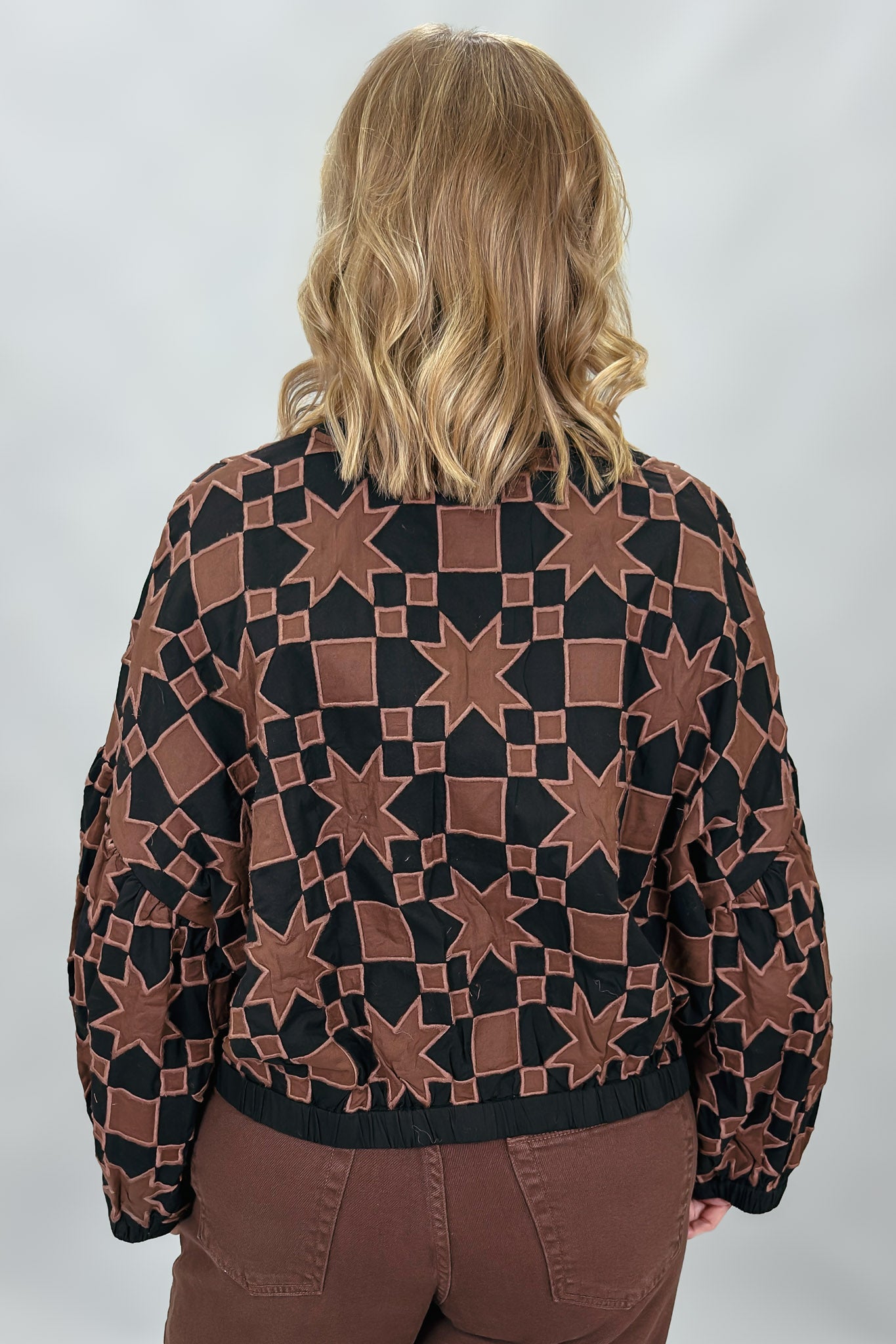 Ivy Jane black quilted jacket with brown stars and squares; back view.