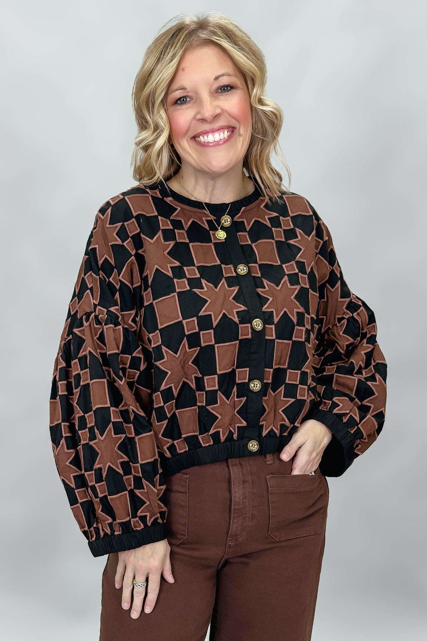 Ivy Jane black quilted jacket with brown stars and squares; front model view.