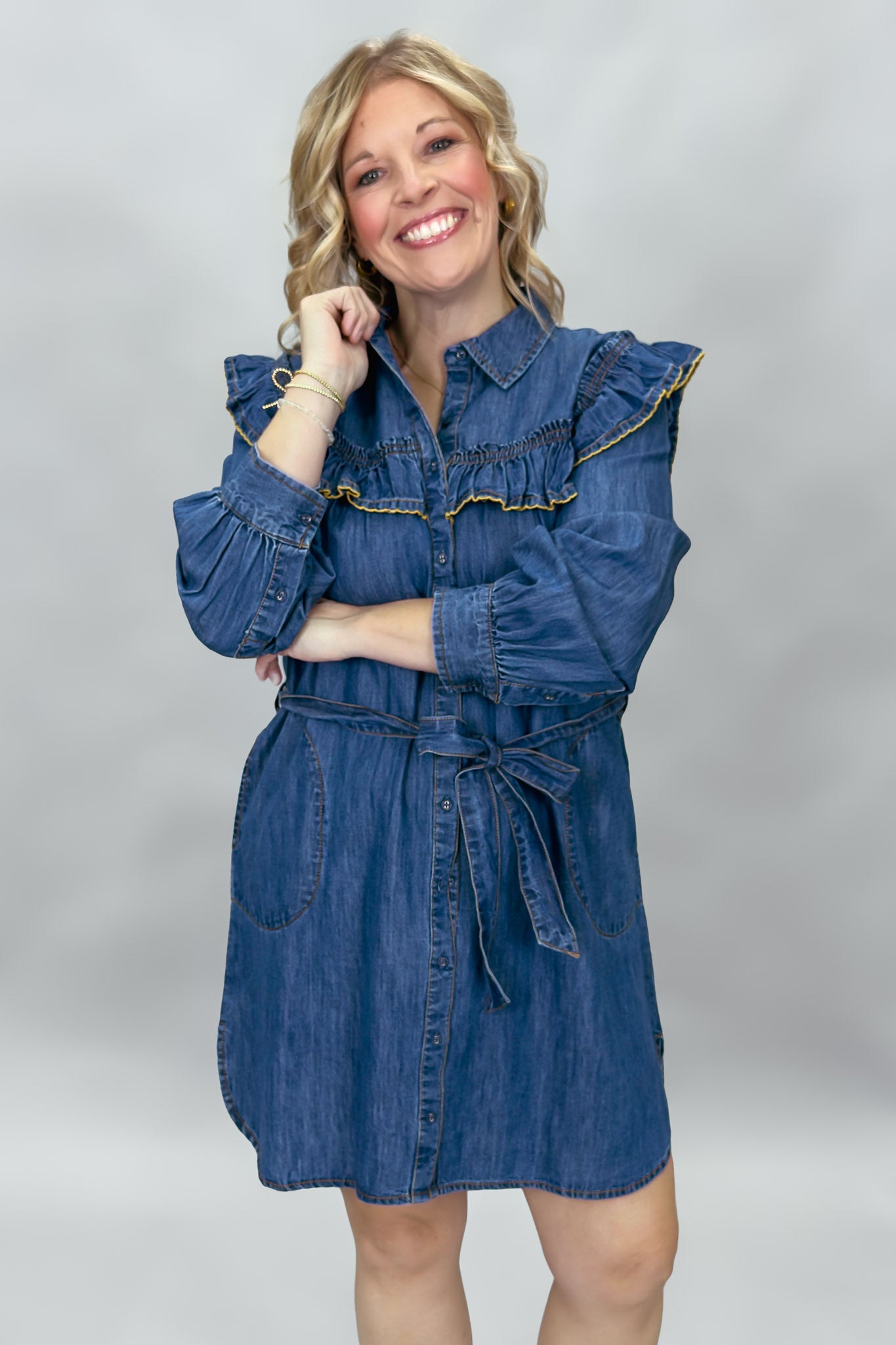 Ivy Jane blue denim mini dress with ruffled yoke and waist tie; angled model view.