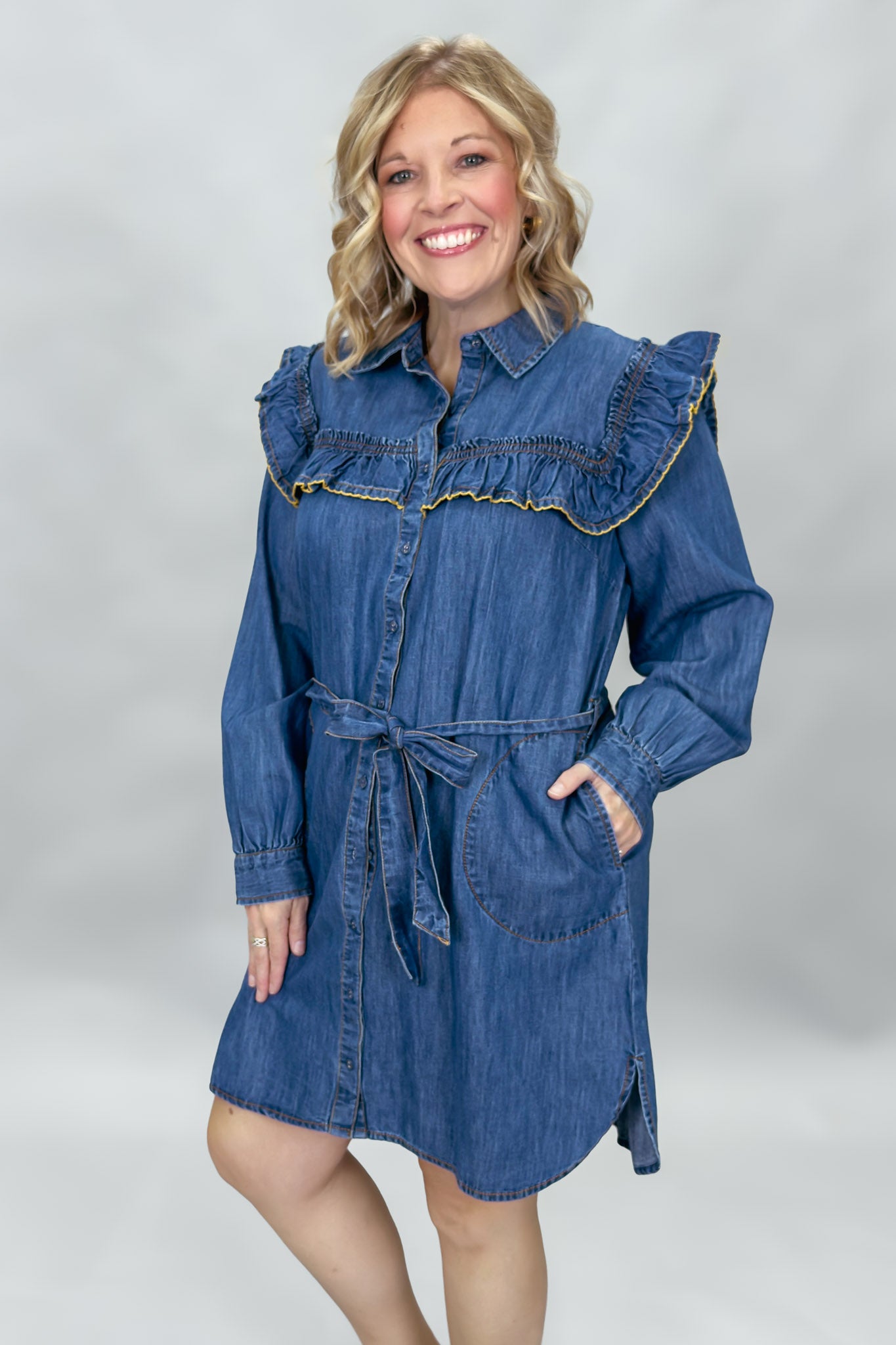 Ivy Jane blue denim mini dress with ruffled yoke and waist tie; angled model view.