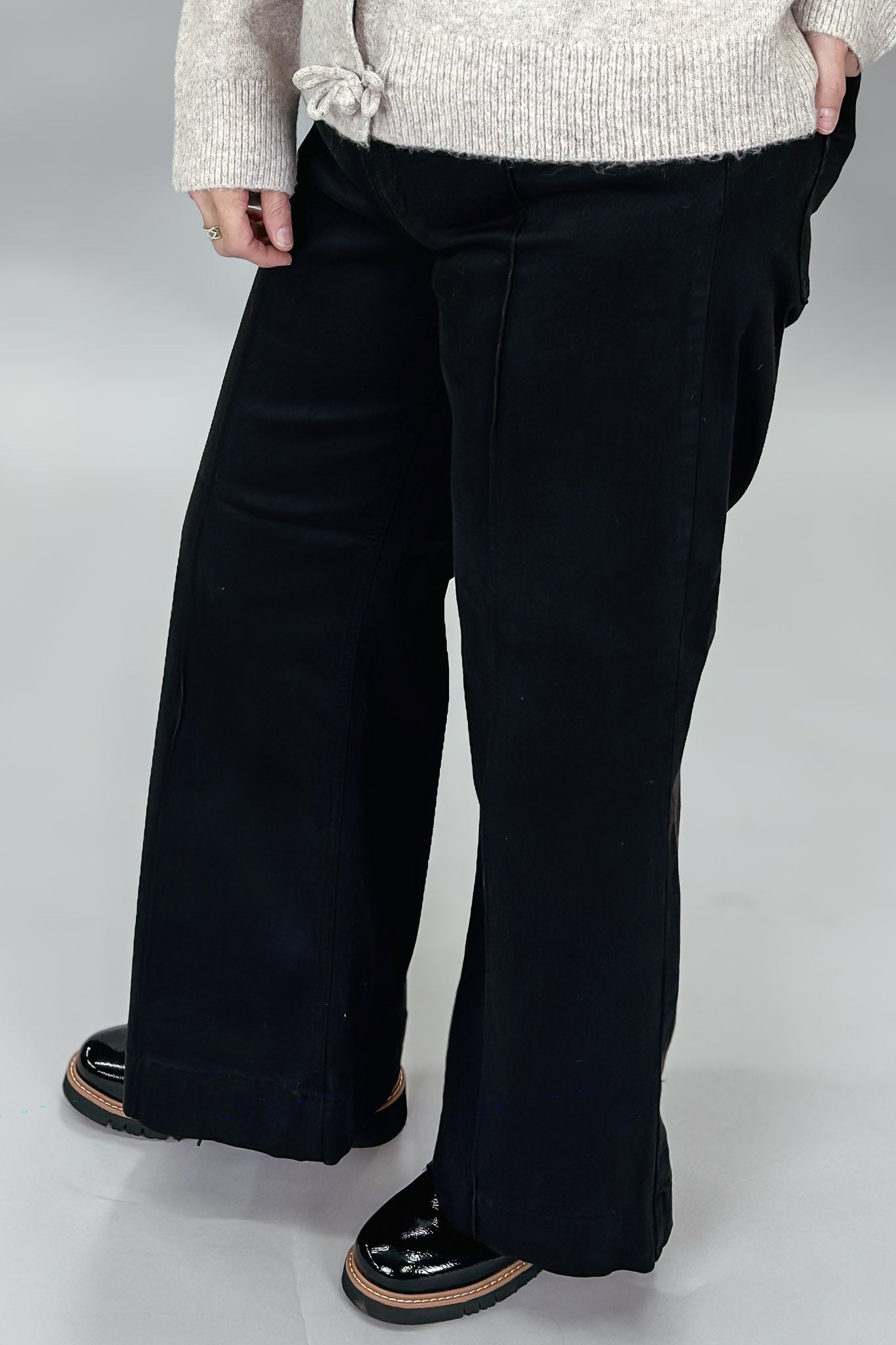 Just Black Denim black wide-leg jeans with front seam detail; angled model view.