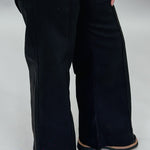 Just Black Denim black wide-leg jeans with front seam detail; angled model view.