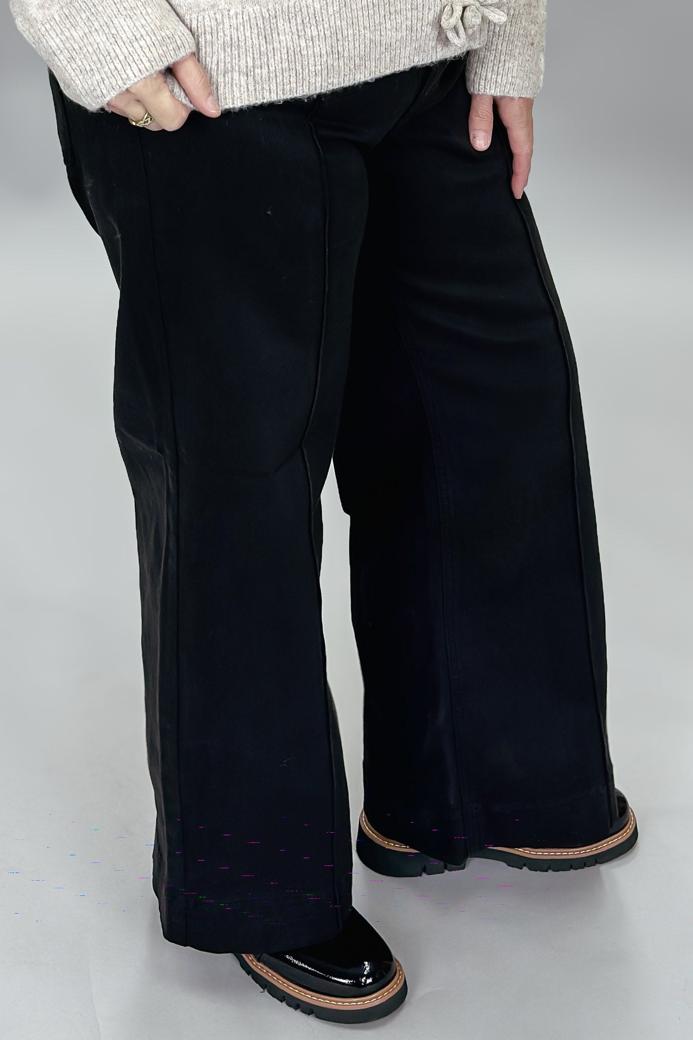 Just Black Denim black wide-leg jeans with front seam detail; angled model view.
