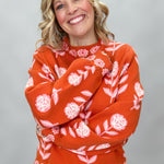 THML orange and pink floral mock-neck sweater with scalloped edges; front model view.