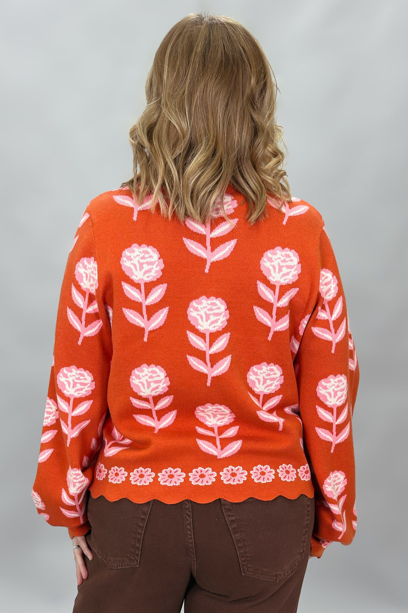 THML orange and pink floral mock-neck sweater with scalloped edges; back view.