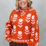 THML orange and pink floral mock-neck sweater with scalloped edges; front model view.