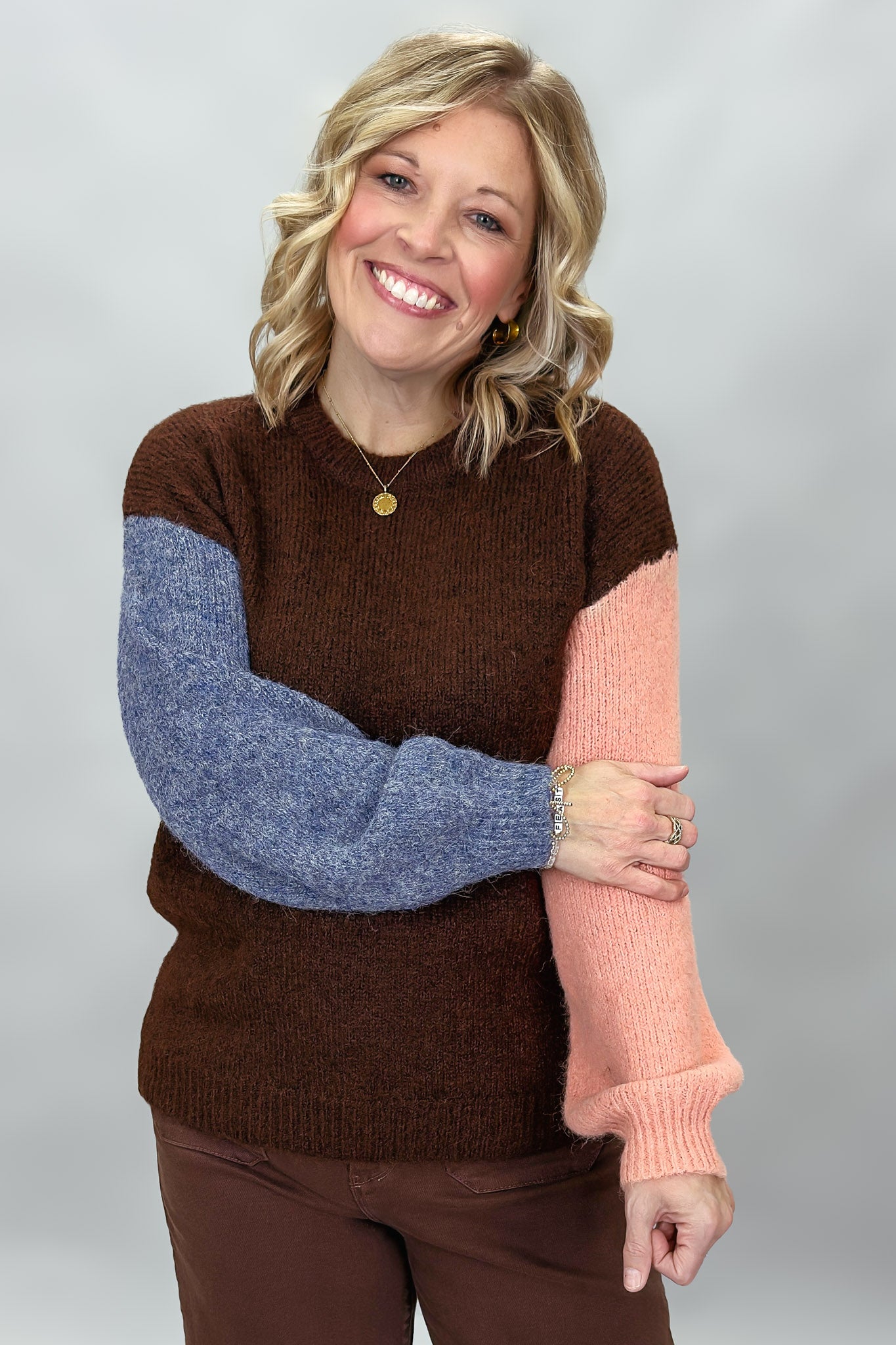 Compania Fantastica mocha sweater with blue and pink sleeves; front model view.