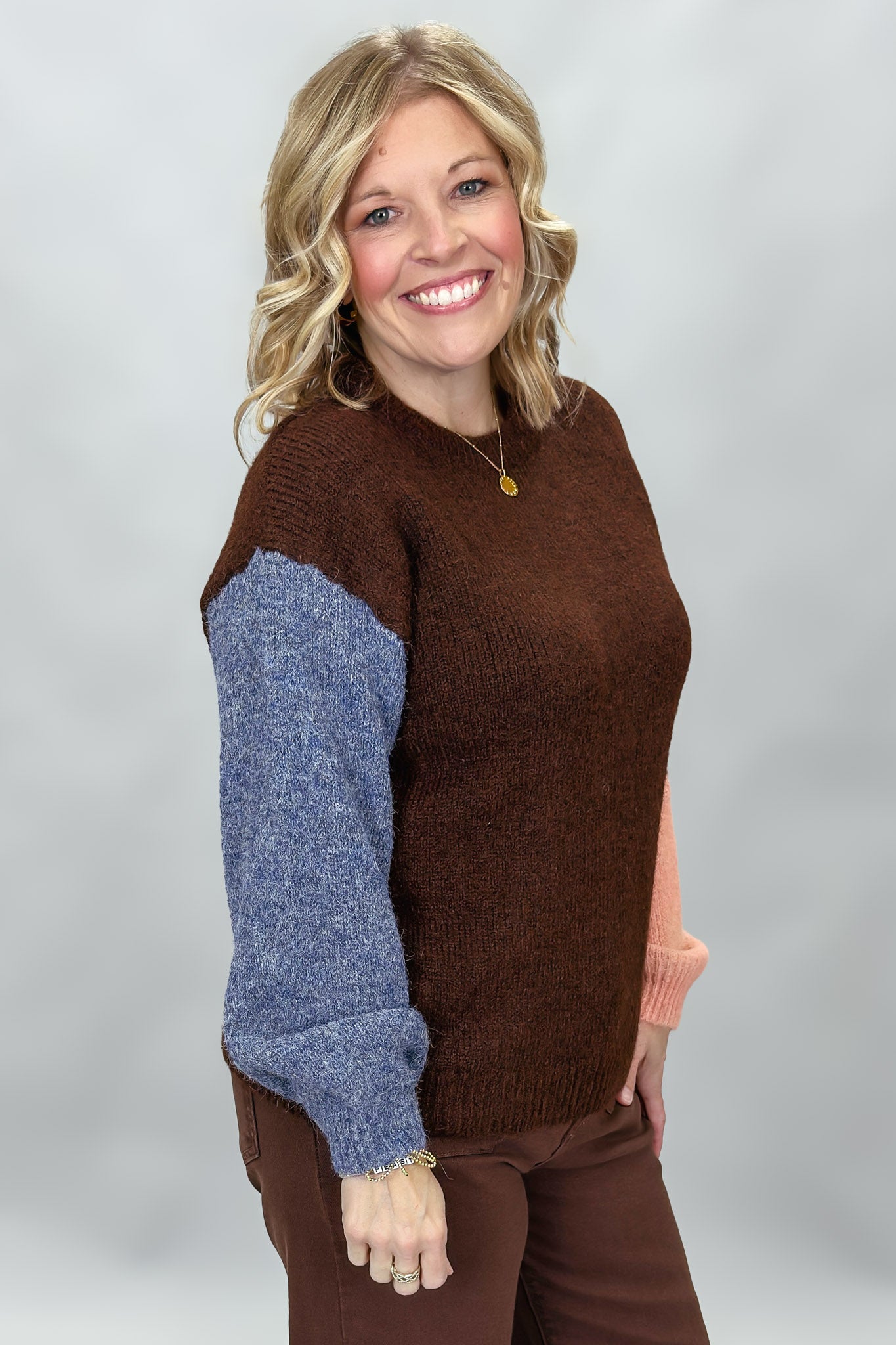 Compania Fantastica mocha sweater with blue and pink sleeves; angled model view.