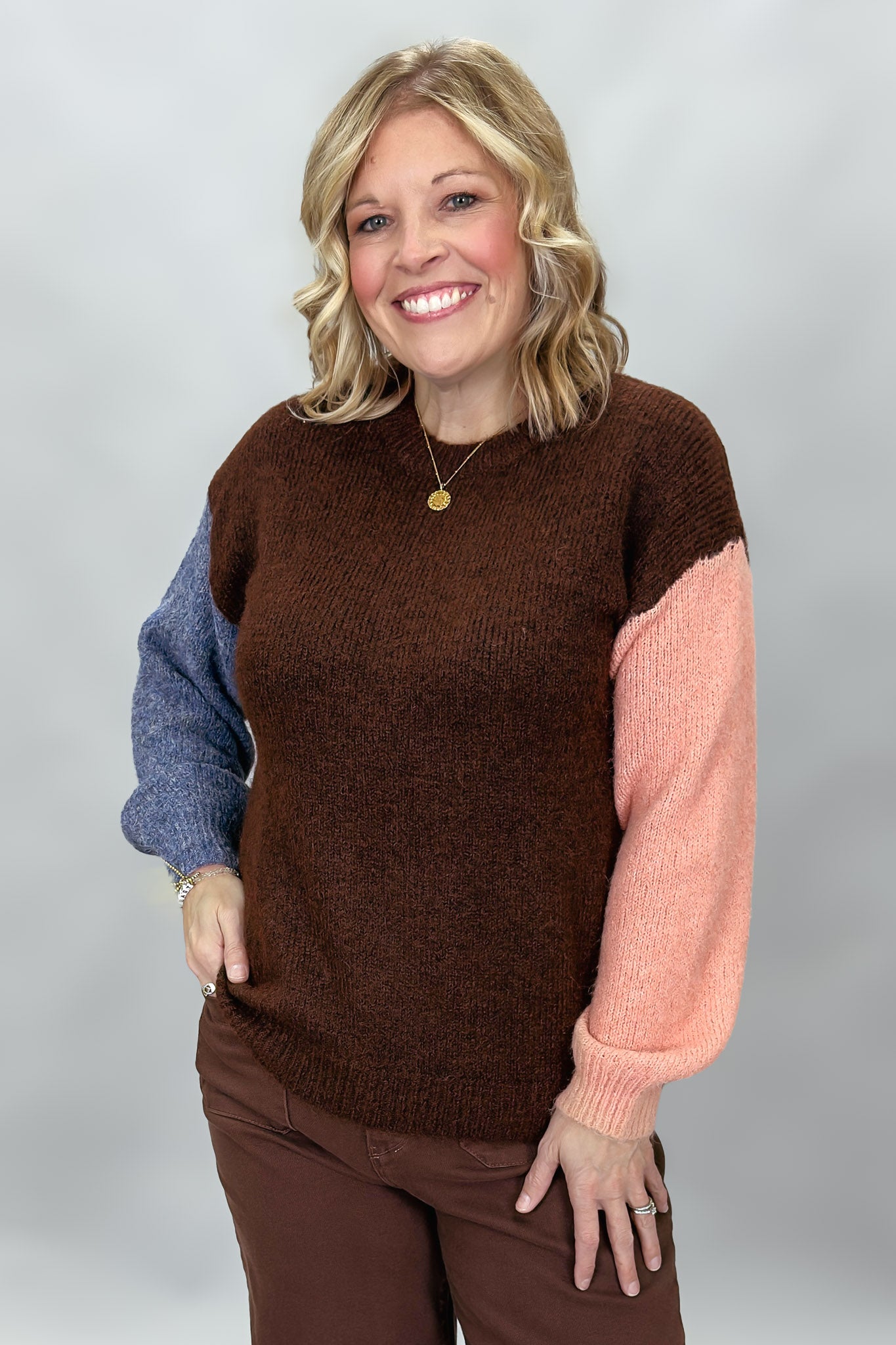 Compania Fantastica mocha sweater with blue and pink sleeves; front model view.