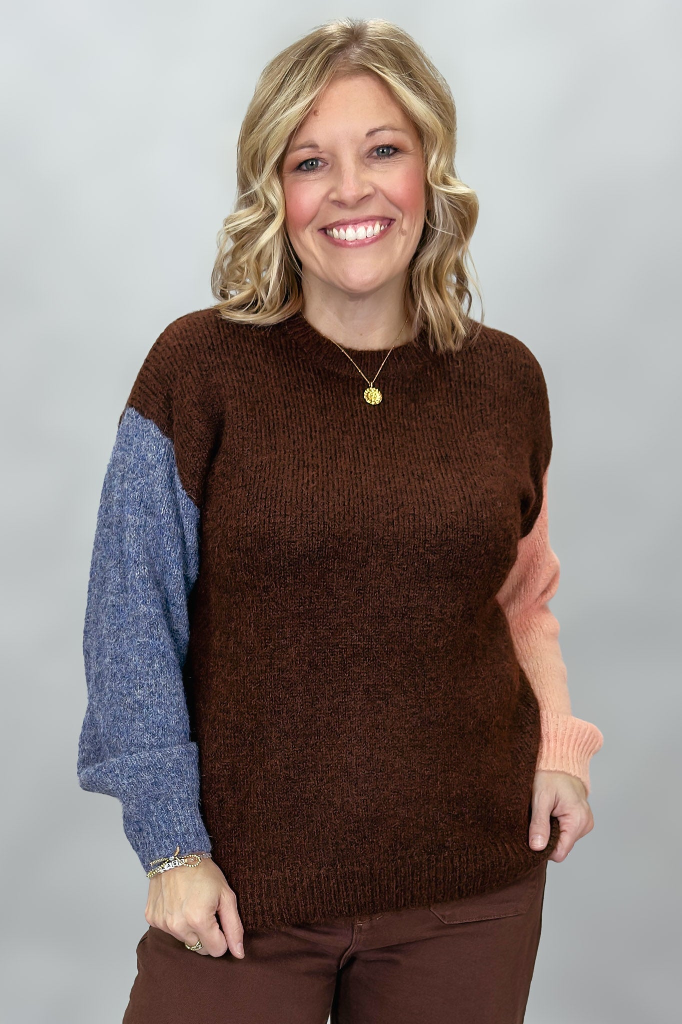 Compania Fantastica mocha sweater with blue and pink sleeves; front model view.