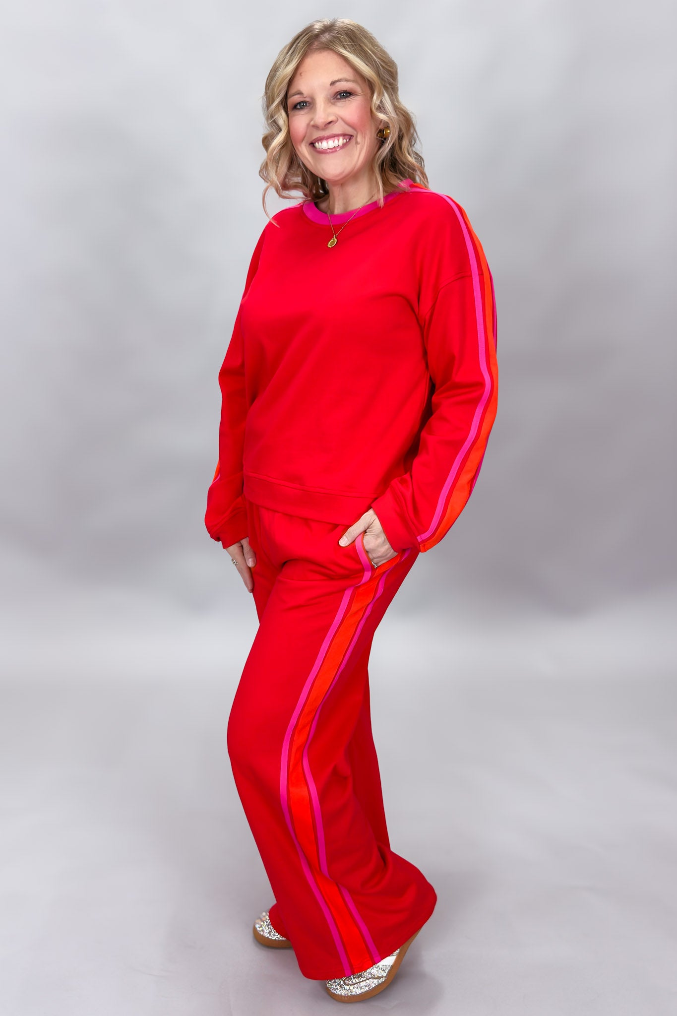 FATE red crewneck top and wide-leg pants set with pink stripes; angled model view.