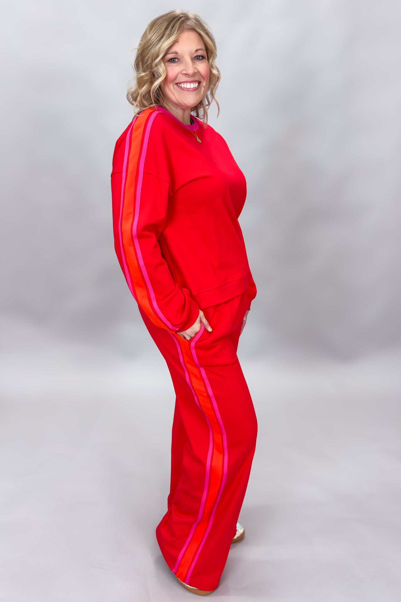 FATE red crewneck top and wide-leg pants set with pink stripes; angled model view.