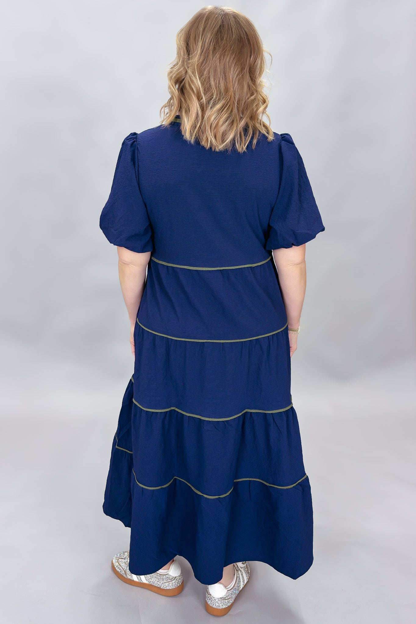 Mary Square navy tiered dress with contrast piping and short puffed sleeves; back view.