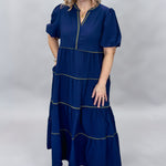 Mary Square navy tiered dress with contrast piping and short puffed sleeves; front model view.