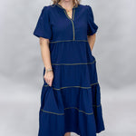 Mary Square navy tiered dress with contrast piping and short puffed sleeves; front model view.