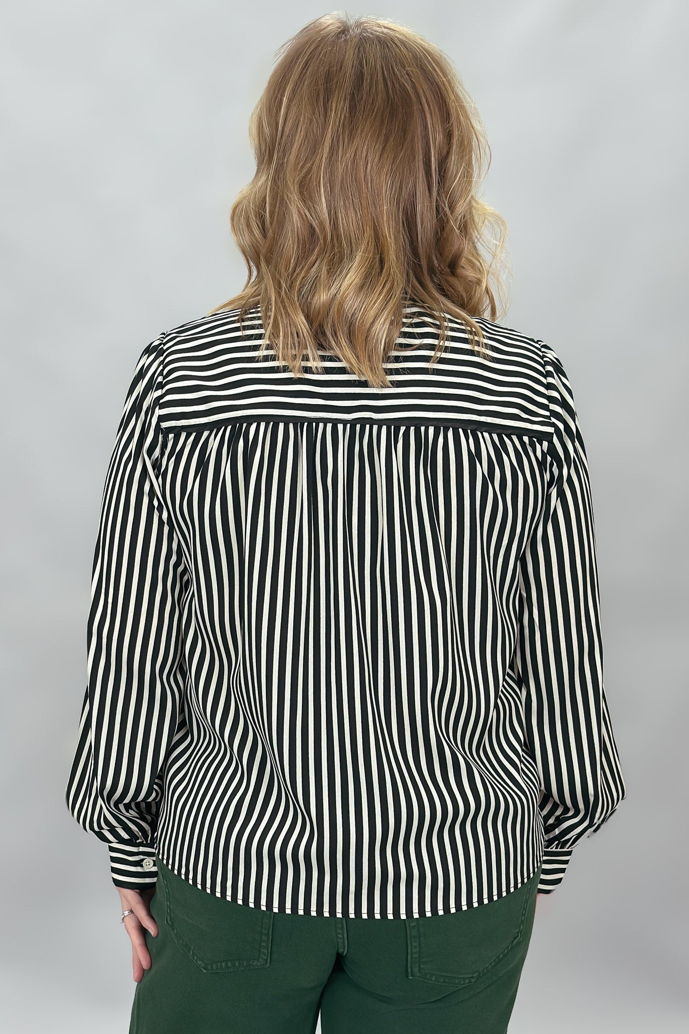 FATE black and cream striped tie-neck blouse with gathered cuffs; back view.