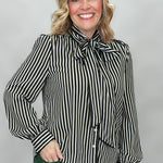 FATE black and cream striped tie-neck blouse with gathered cuffs; angled model view.