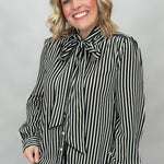 FATE black and cream striped tie-neck blouse with gathered cuffs; front model view.