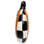 Side view of narrow orange ceramic pumpkin sitter with black-and-white checks