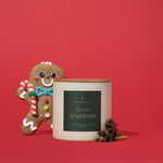 Hico Candle Co. Spiced Gingerbread candle with Christmas decorations against a red background; display suggestion, props not included